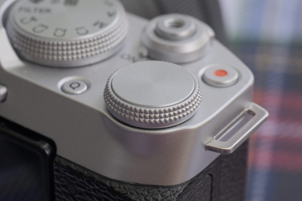 The rear command dial of the Fujifilm X-M5. To its upper left the record button with a red dot, to its up right the shutter, and to its left the control dial.